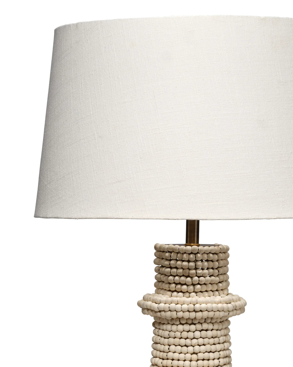 Artisanal table lamp made from hand carved mango beads with a dark brass base and white linen lampshade.