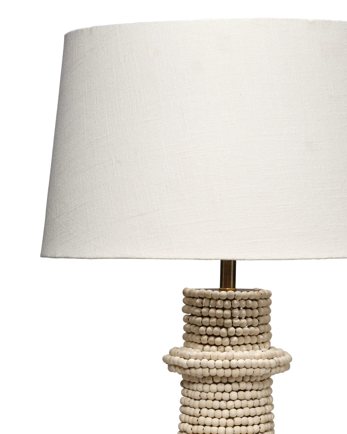 Artisanal table lamp made from hand carved mango beads with a dark brass base and white linen lampshade.