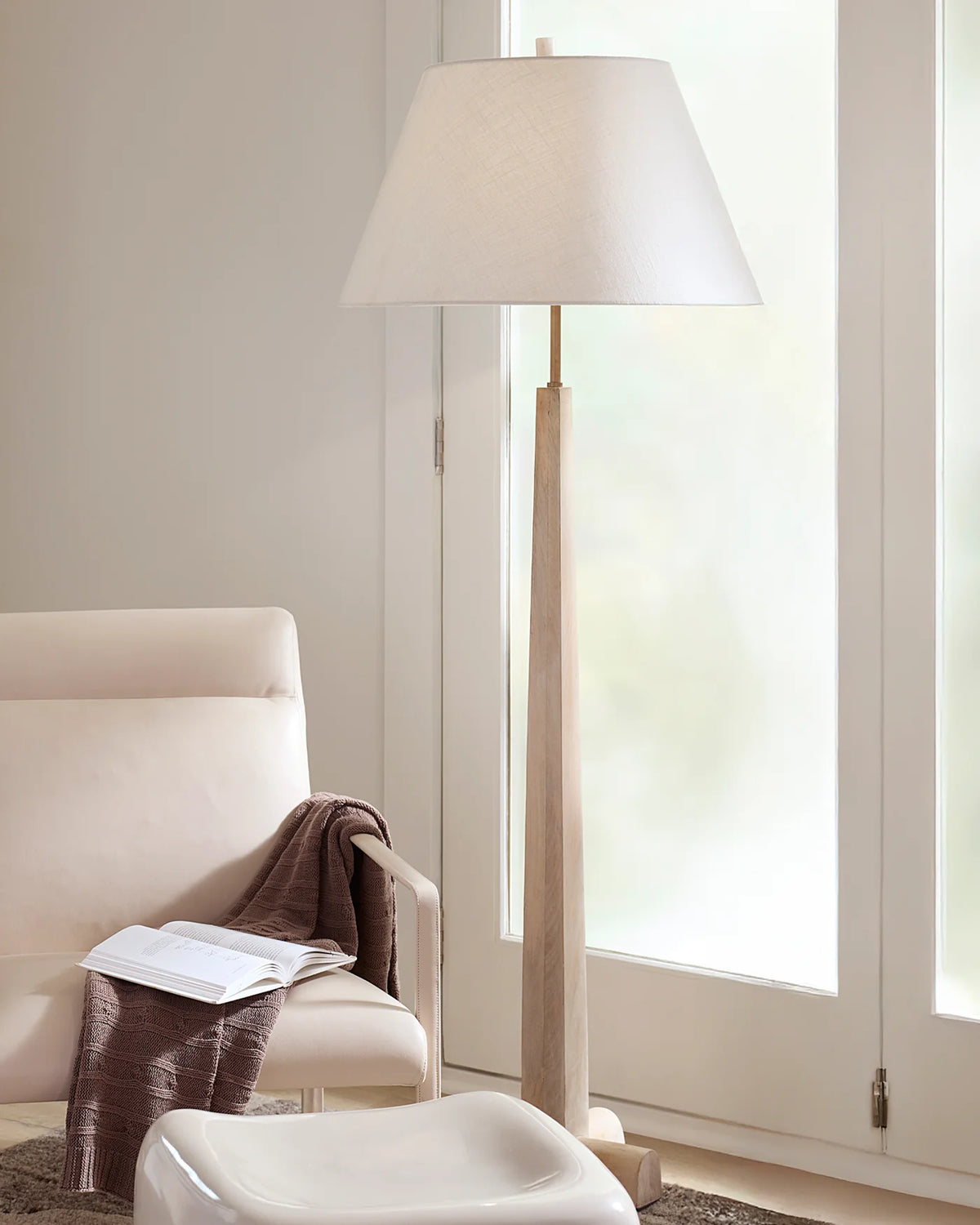 Tall turned wood floor lamp with washed white finish and a tapered white linen lampshade