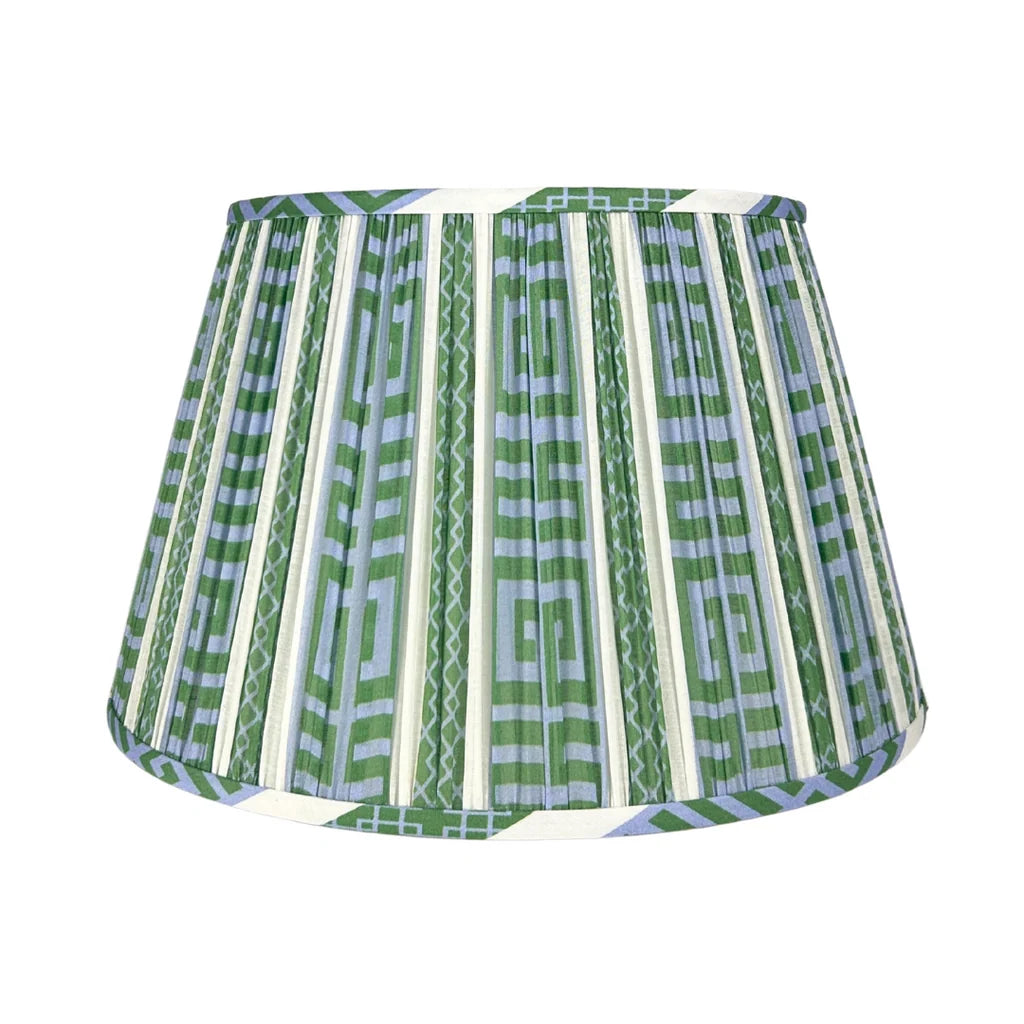International Blue and Green McKenna Lampshade featuring a geometric Greek key pattern in blue, green, and ivory, finely pleated fabric, coordinating patterned trim, and a classic tapered silhouette.