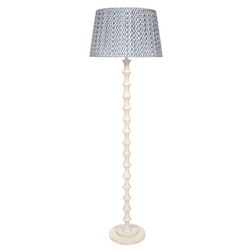 Celeste Floor Lamp featuring a tall, sculptural whitewashed base with stacked hourglass-shaped detailing, a round base, and a blue-and-white patterned lampshade.