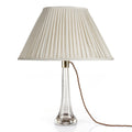 Fermoie Cream Moire oval lampshade styled on a glass table lamp in Nashville, Tennessee
