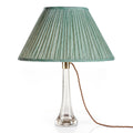Fermoie Green Strié oval lampshade styled on a glass table lamp in Nashville, Tennessee