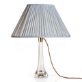 Fermoie Light Blue Strié oval lampshade styled on a glass table lamp in Nashville, Tennessee