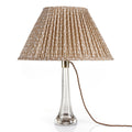 Fermoie Nut Brown Rabanna Oval Lampshade styled on a glass table lamp in Nashville, Tennessee