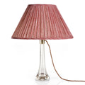Fermoie Red Strié oval lampshade styled on a glass table lamp in Nashville, Tennessee