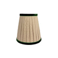 Pleated natural linen chandelier lampshade with emerald green velvet trim along the top and bottom edges, featuring a classic tapered silhouette.