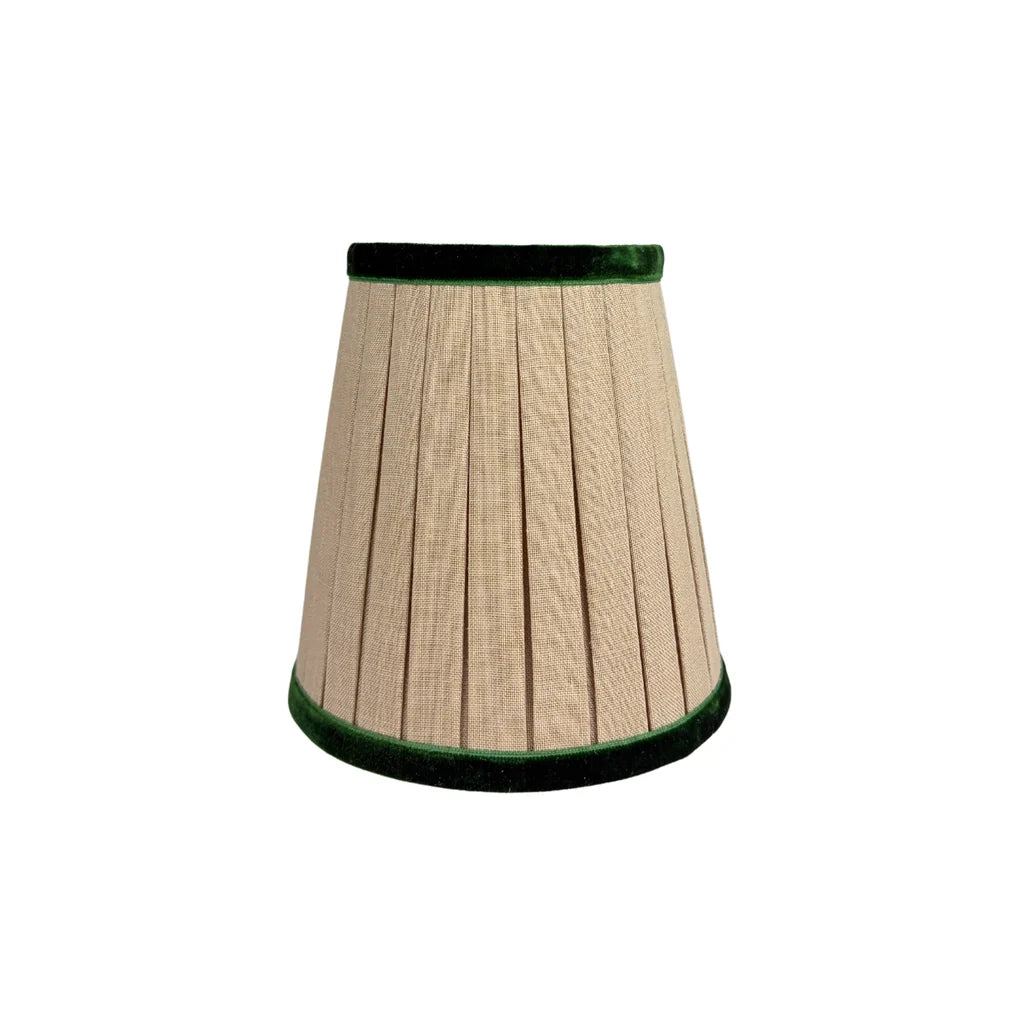 Pleated natural linen chandelier lampshade with emerald green velvet trim along the top and bottom edges, featuring a classic tapered silhouette.