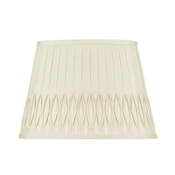 Eggshell silk lampshade with vertical pleating and intricate bottom smocked detailing in a tapered empire silhouette.