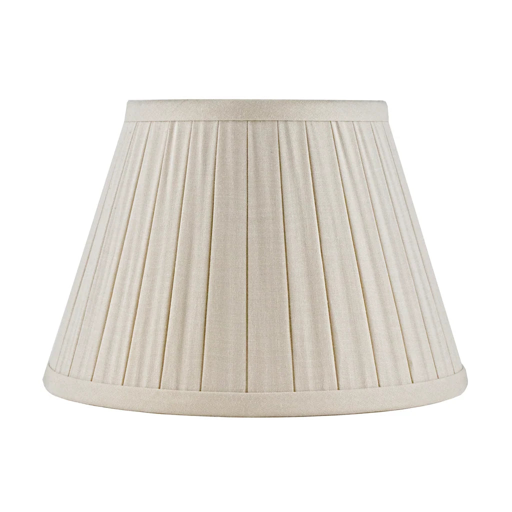 Eggshell linen lampshade with tailored box pleats, matching fabric trim, and a classic tapered empire silhouette.