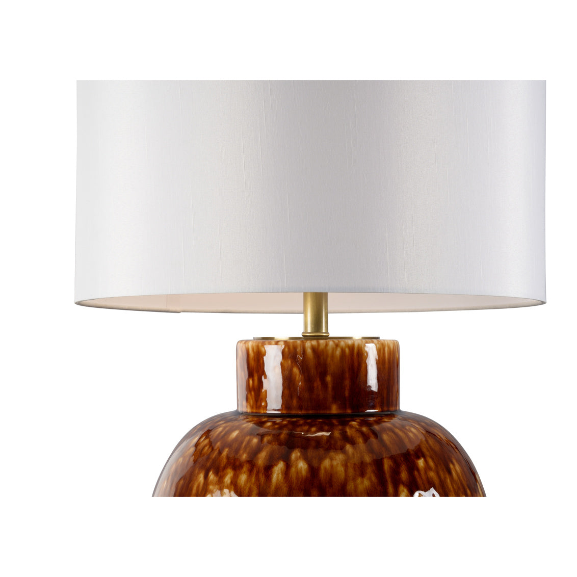 Table lamp with a tortoiseshell base and white drum lampshade on a white background