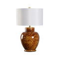 Table lamp with brown glazed ceramic base and white drum lampshade on a white background