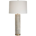 Tall, neutral, ceramic table lamp with a brass base and linen drum