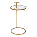 Orson Martini Table featuring a round glass top, slender antique gold metal frame, sculptural geometric detailing, and circular open base.
