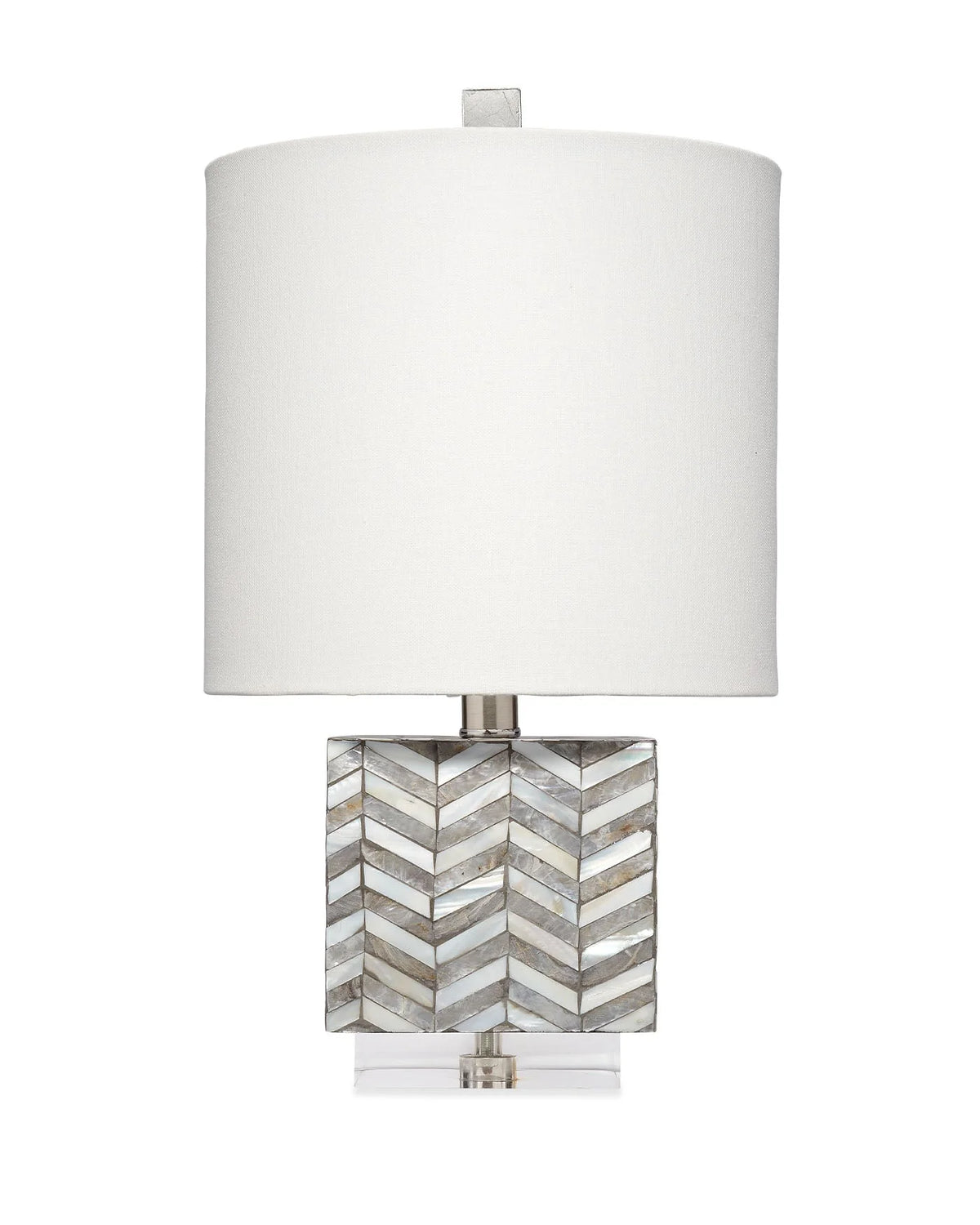 A table lamp with a large white drum shade, a square base made of inlaid mother-of-pearl chevron pattern, and a clear acrylic foot.