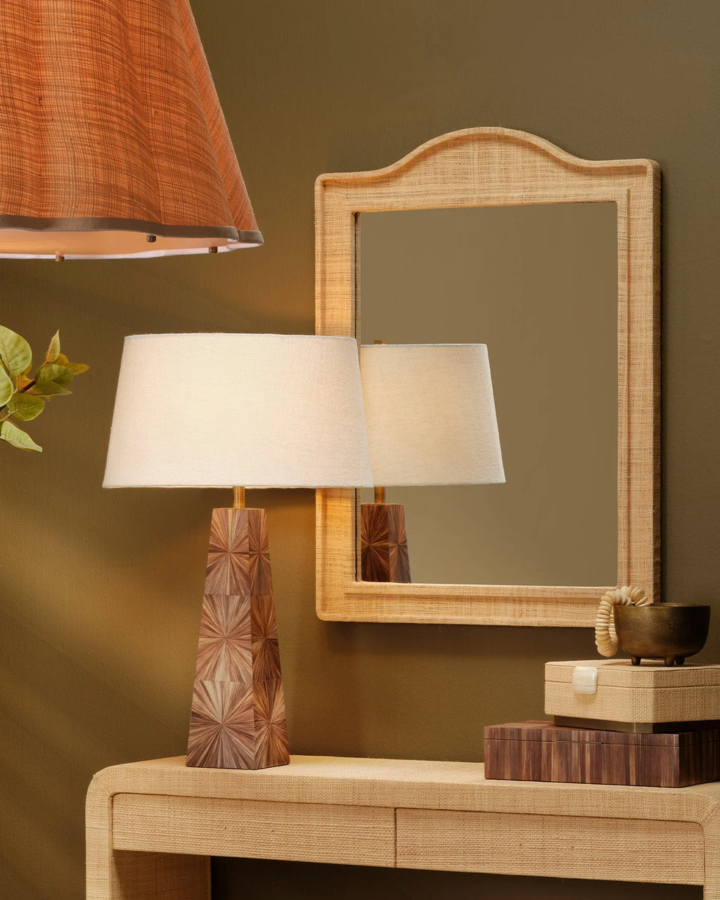 Solana Table Lamp featuring a rich brown dyed-straw base with a radiating sunburst pattern, antique brass accents, and a classic white linen drum shade.