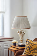 Sorella Glen Oatmeal Shirred Empire Lampshade with Caramel Trim styled on a white table lamp in Nashville, Tennessee
