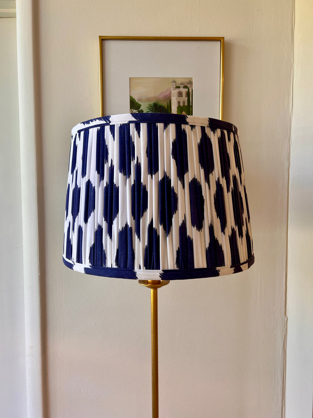 Sorella Glenn Navy Ikat Drum Lampshade styled on a brass floor lamp in Nashville, Tennessee