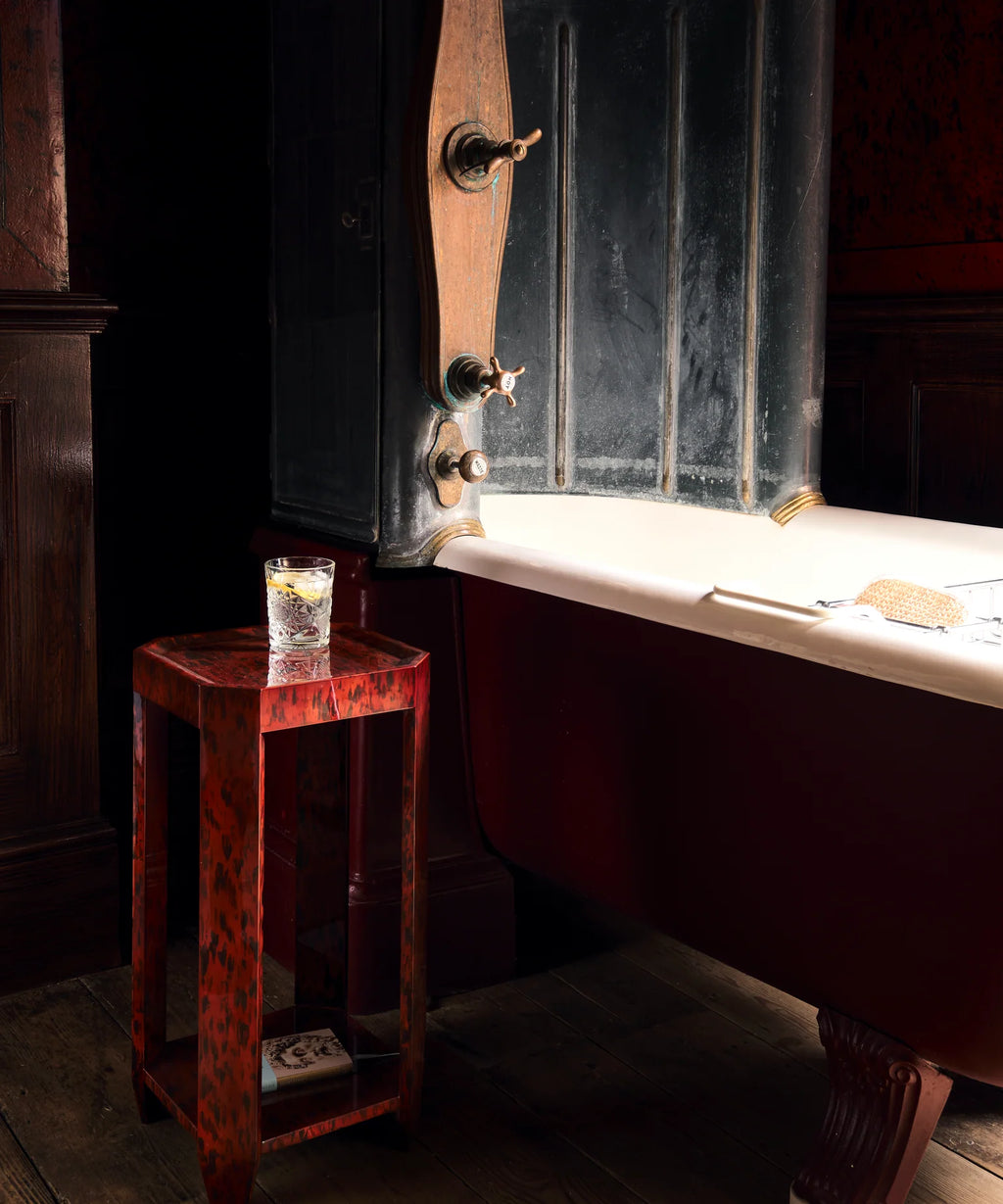 Felix Drinks Table in Brown Tortoiseshell with a glossy red-brown lacquer finish, raised-edge square top, open geometric frame, and lower shelf.
