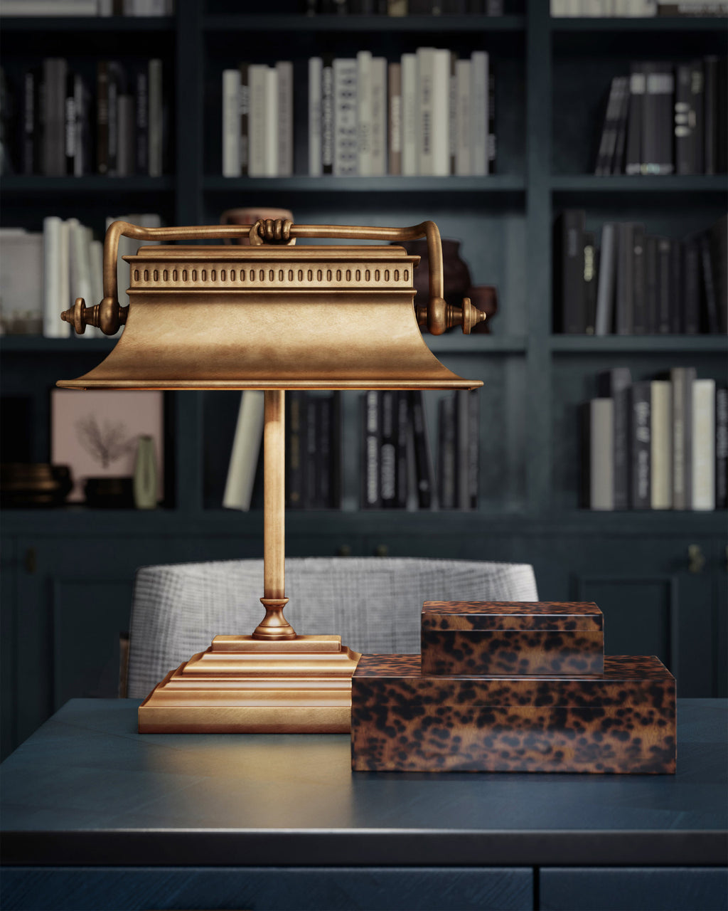 Tortoise shell decorative box set styled in a moody library with an antiqued brass metal lamp