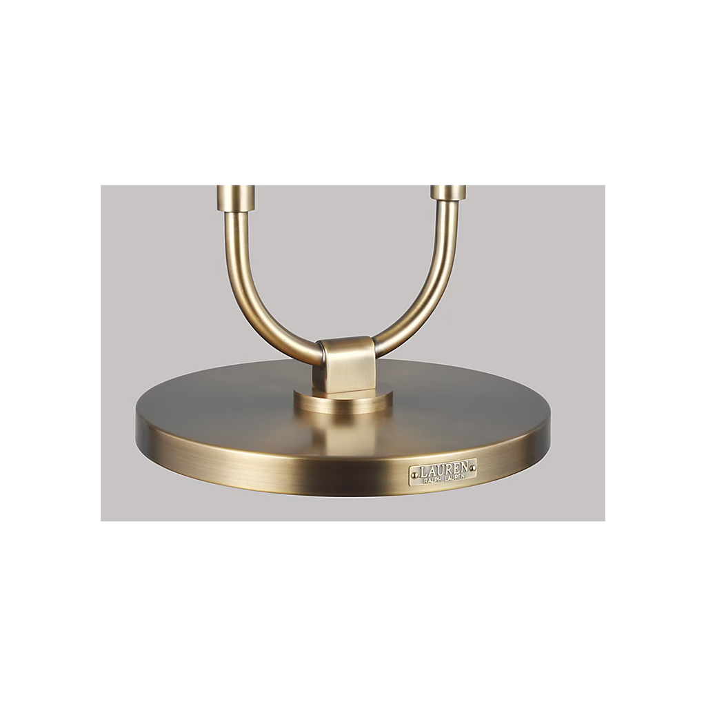 Katie Table Lamp by Lauren Ralph Lauren for Visual Comfort, featuring saddle leather-wrapped supports, warm brass accents, a circular brass base, and a white tapered lampshade.