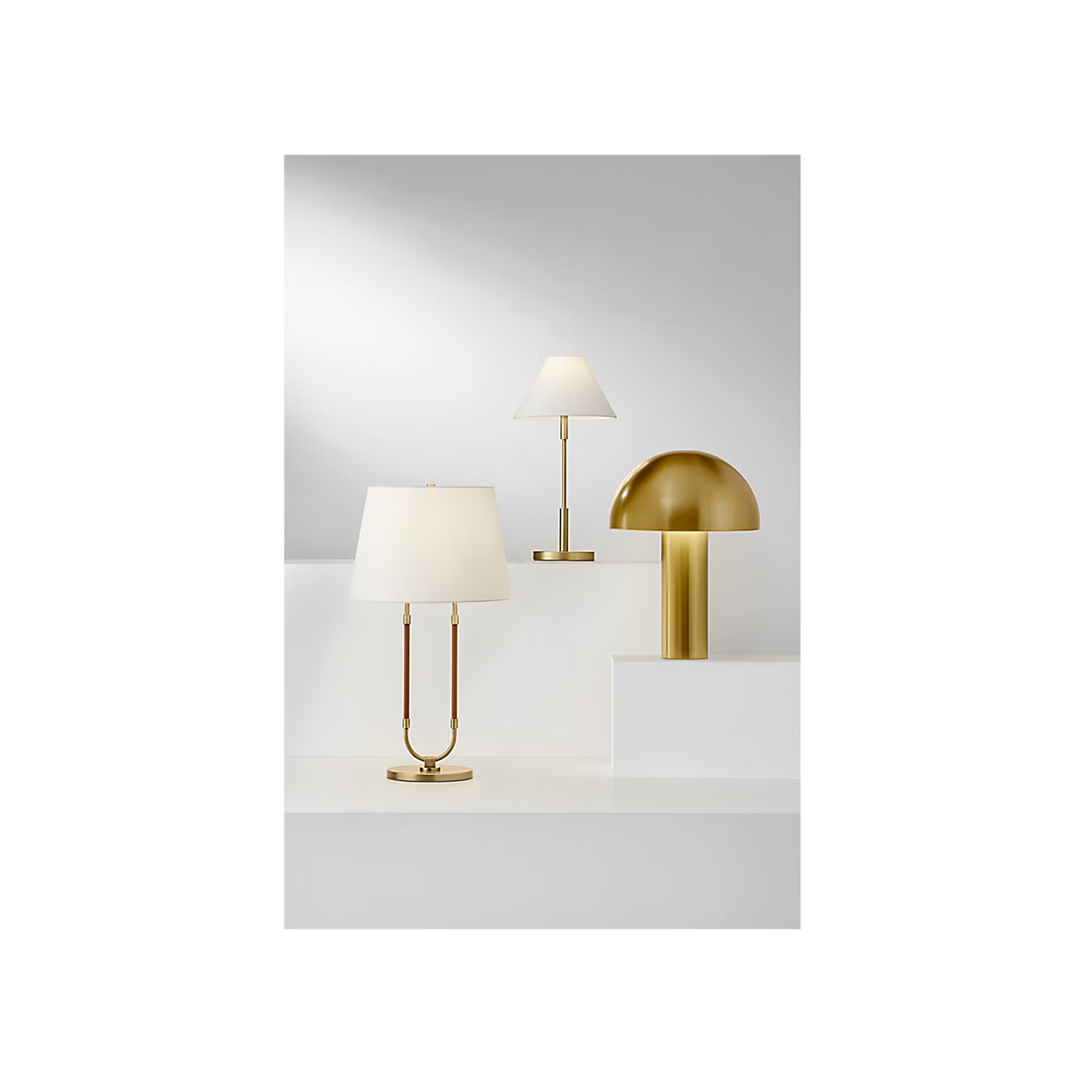 Katie Table Lamp by Lauren Ralph Lauren for Visual Comfort, featuring saddle leather-wrapped supports, warm brass accents, a circular brass base, and a white tapered lampshade.