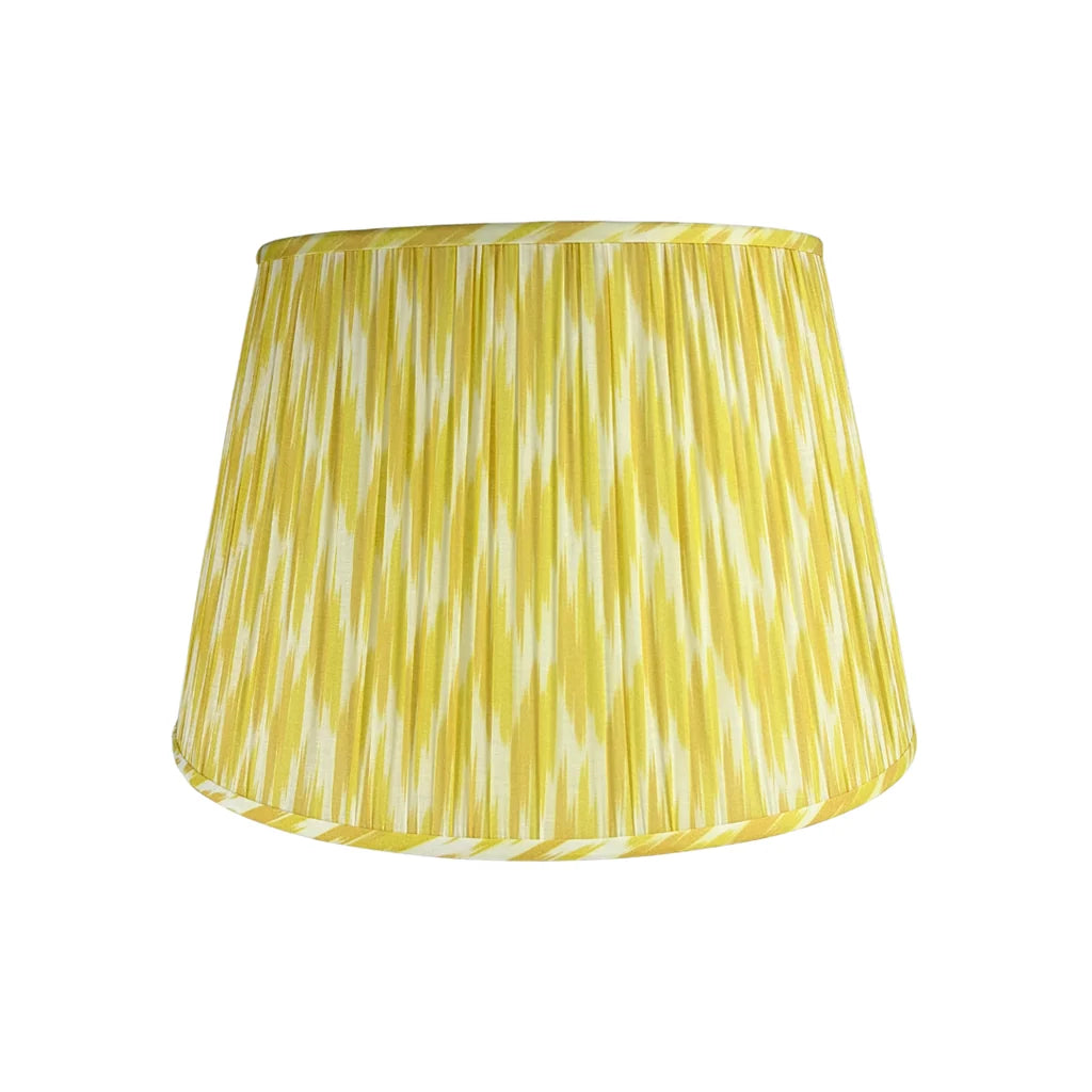 Citron Ikat Lampshade featuring a vibrant yellow and ivory ikat pattern, finely pleated fabric, coordinating trim, and a classic tapered silhouette.